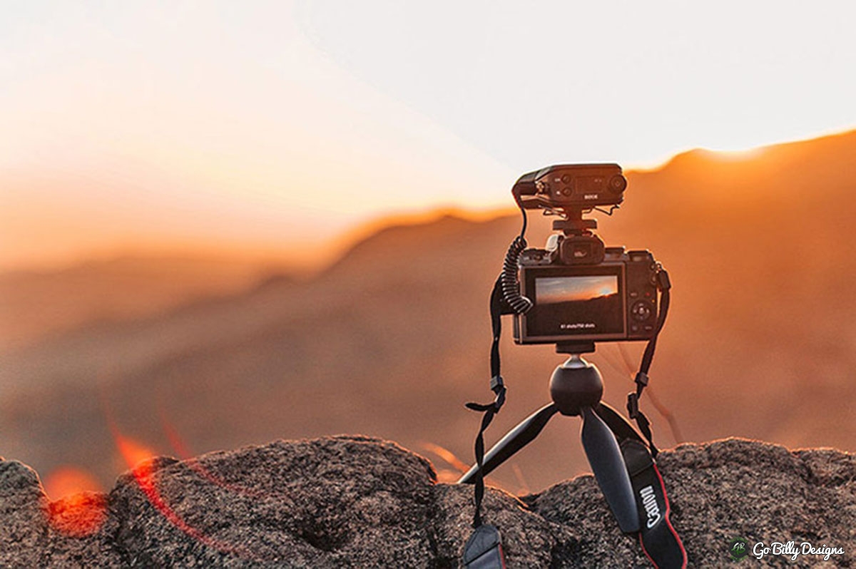 camera on tripod with a sunset in the background
